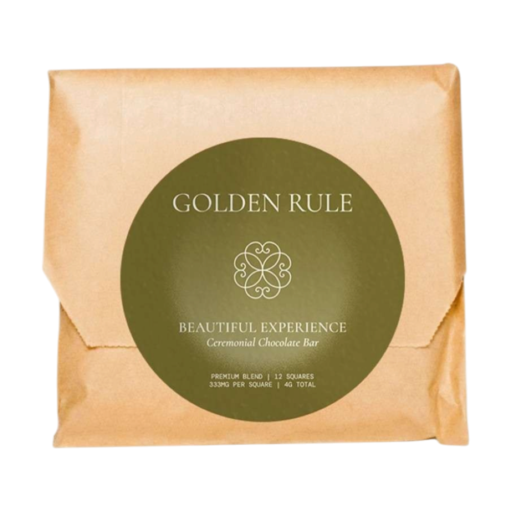 Golden Rule Beautiful Experience ceremonial chocolate bar in a kraft paper wrapper with an olive-green round label