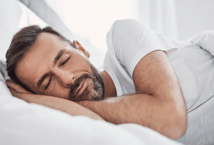 man with beard sleeping on white sheets